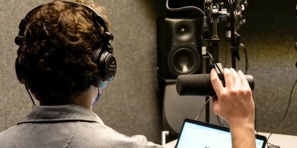 Student recording in podcast booth