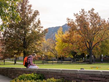 Student outside on CU ɫ campus in the Fall