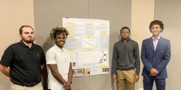 Students posing with a research poster